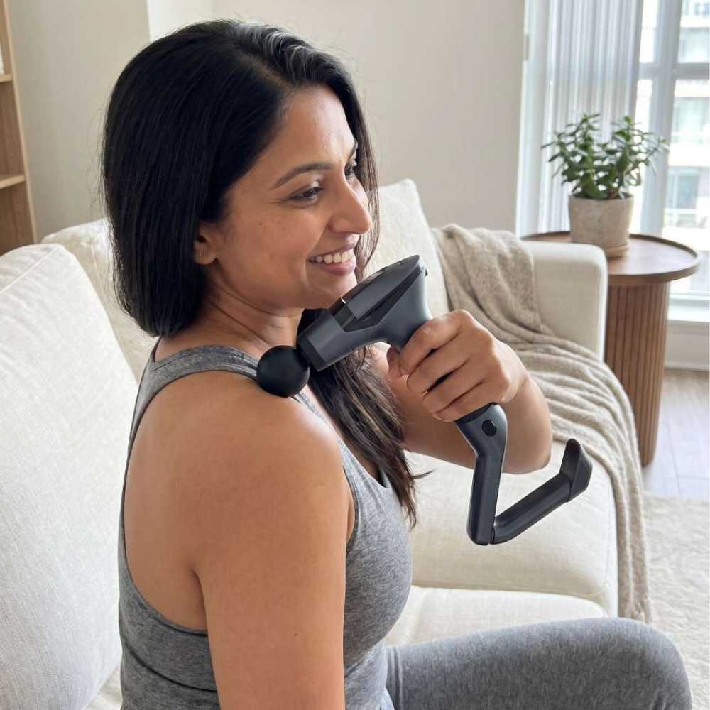 Woman using a neck massager in a living room setting