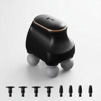 Black handheld device with spherical base and multiple attachments on a white background